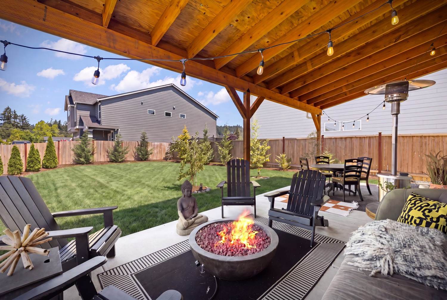 320 square foot covered entertainer's patio with fire pit and string lights
